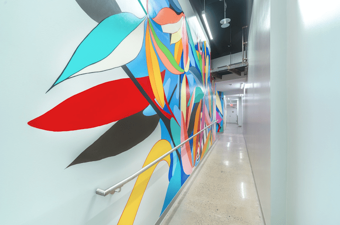 Example of exhibition design,: a hallway with a colorful mural on the wall