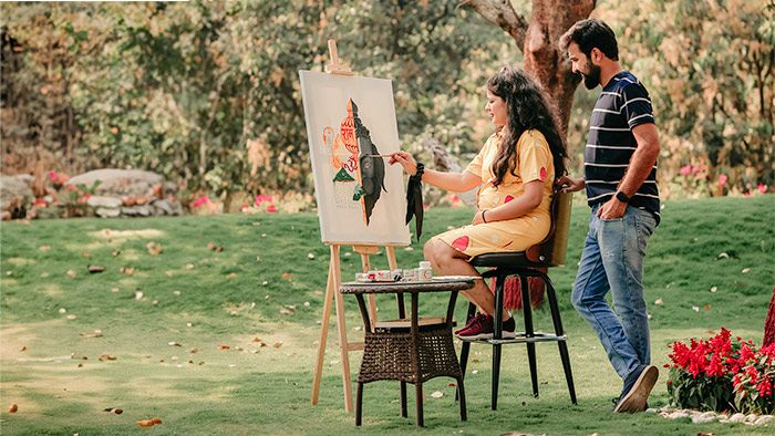 un artista pintando afuera sobre el césped.