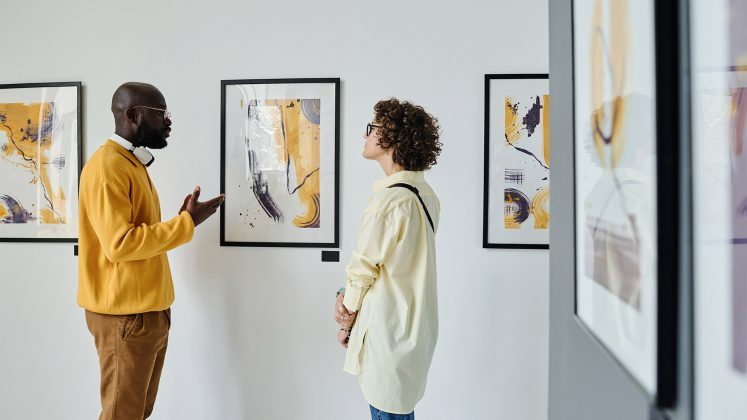 a group of people looking at art on the wall