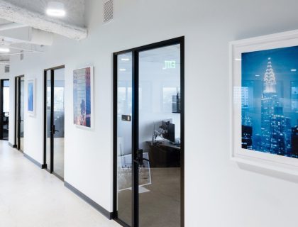 a hallway with glass doors and pictures on the wall