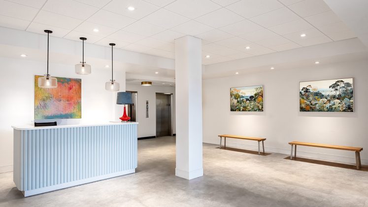 a lobby with a white wall and a blue reception desk