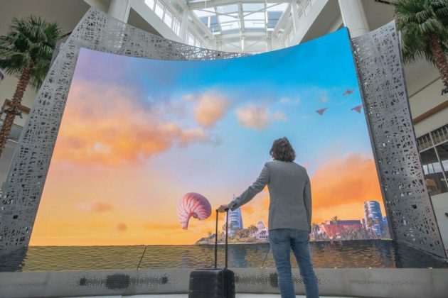 a person standing in front of a large screen with a large screen