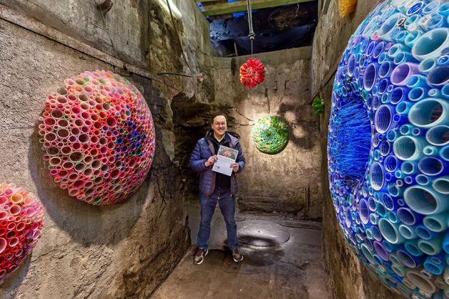 a man standing in a room with colorful objects