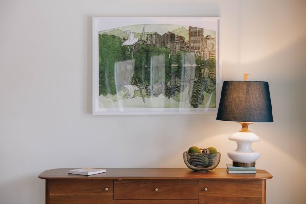 a table with a lamp and a picture on the wall