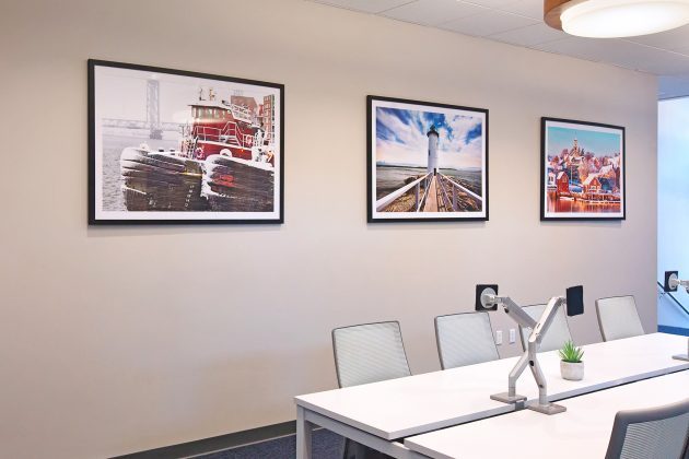 Framed artworks on office wall.