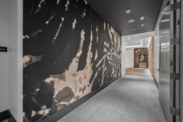 a wallcovering in a hallway with artwork at the end of the hallway
